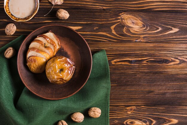 Bebida y nueces cerca de manzanas y servilletas al horno