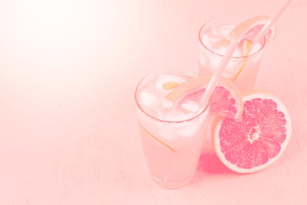 Bebida y pomelo frescos de la dieta sana del verano en fondo rosado