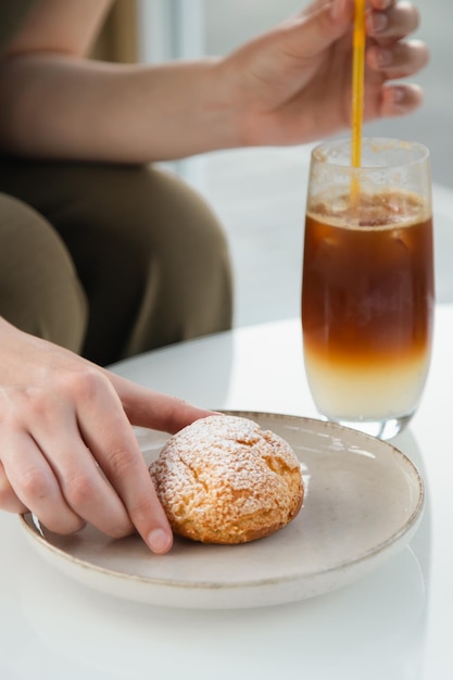 Bebida refrescante de café tónico espresso en un vaso y pastel shu