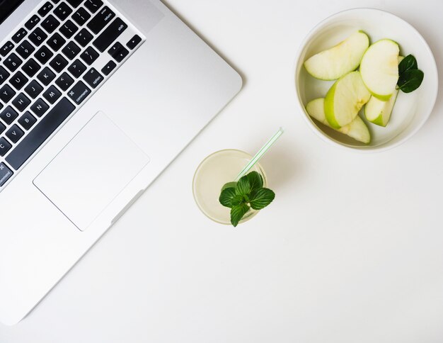 Bebida refrescante con manzanas y portátil