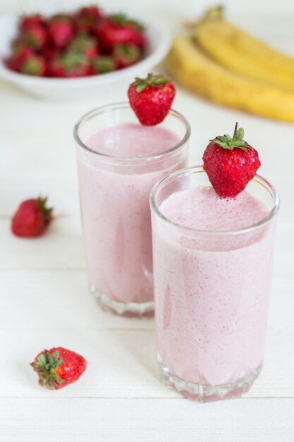 Bebida sana del desayuno del smoothie del plátano de la fresa en vidrio