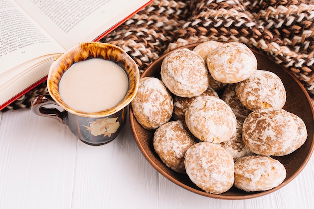 Foto gratuita bebidas y pan de jengibre cerca de bufanda y libro