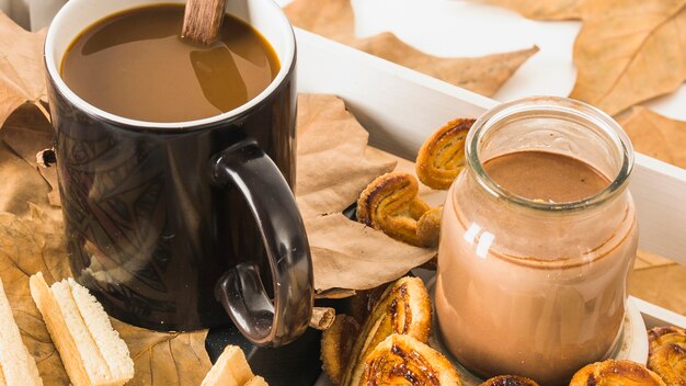 Bebidas de primer plano cerca de pasteles y hojas