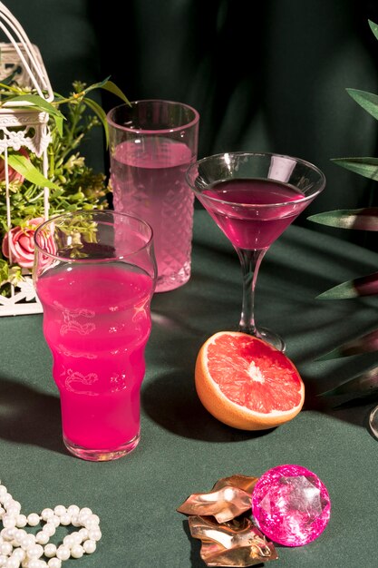 Bebidas rosas junto a artículos femeninos en mesa.