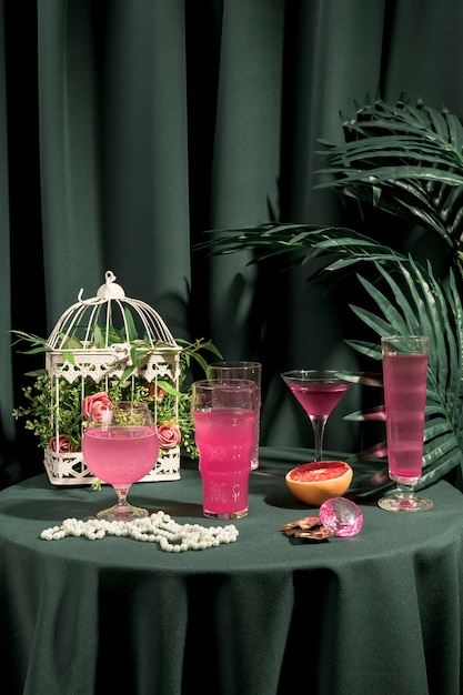 Bebidas rosas junto a ornamentos de moda en mesa.