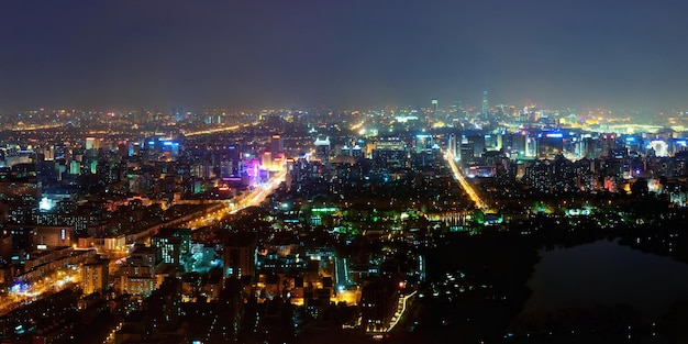 Beijing en vista aérea nocturna con edificios urbanos.