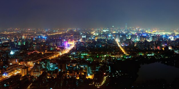 Beijing en vista aérea nocturna con edificios urbanos.