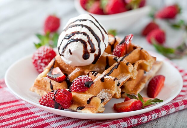 Bélgica gofres con fresas y helado en plato blanco