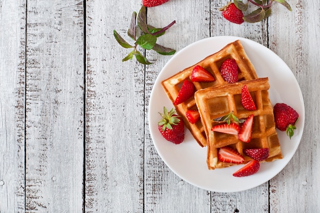 Foto gratuita bélgica gofres con fresas y menta en plato blanco