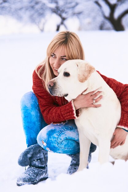 La bella mujer abrazando a un perro