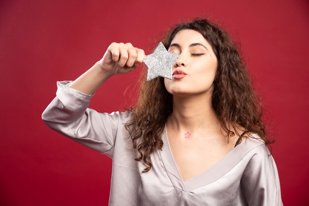 Bella mujer besando a estrella brillante.