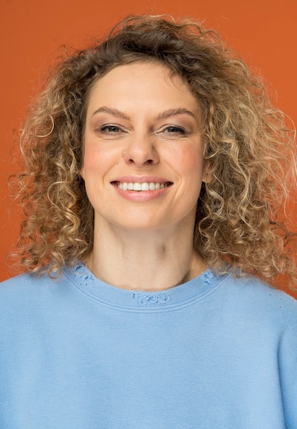 Bella mujer con cabello rubio rizado sonriendo