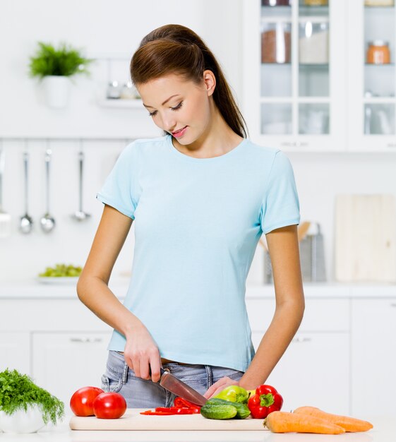 Bella mujer cocinando comida sana en la cocina