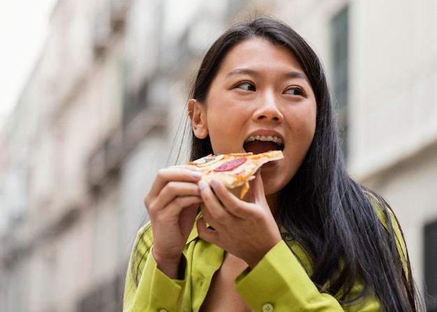 Bella mujer comiendo comida en la calle al aire libre