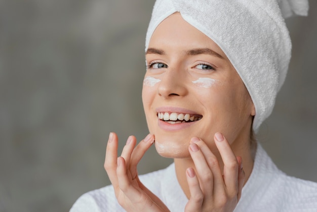 Bella mujer con una crema para el cuidado de la piel