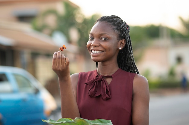 Bella mujer disfrutando de algo de comida en la calle