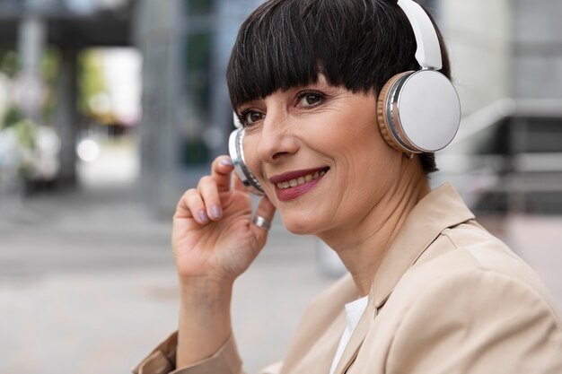 Bella mujer disfrutando de música al aire libre