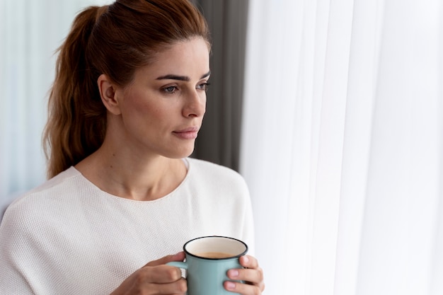 Foto gratuita bella mujer disfrutando de una taza de café