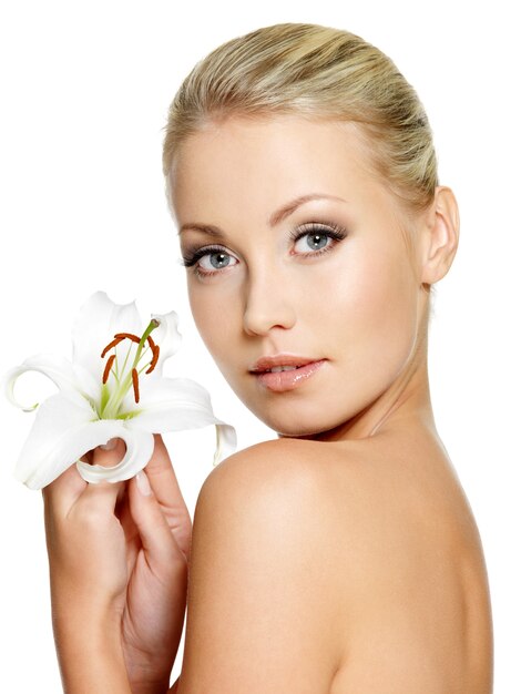 Bella mujer con flor. Retrato de perfil de niña en espacio en blanco