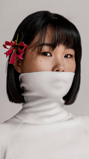 Bella mujer con flor sobre la oreja