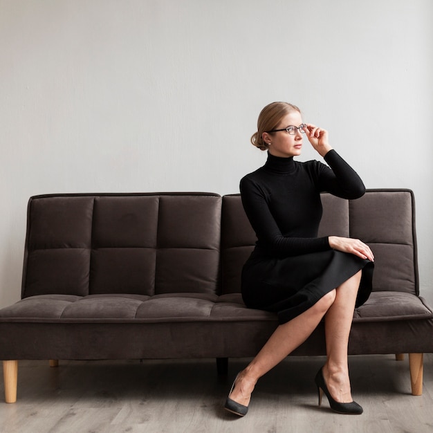 Bella mujer con gafas en el sofá