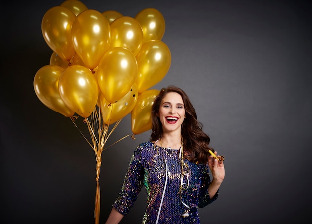 Bella mujer con globos dorados en tiro de estudio