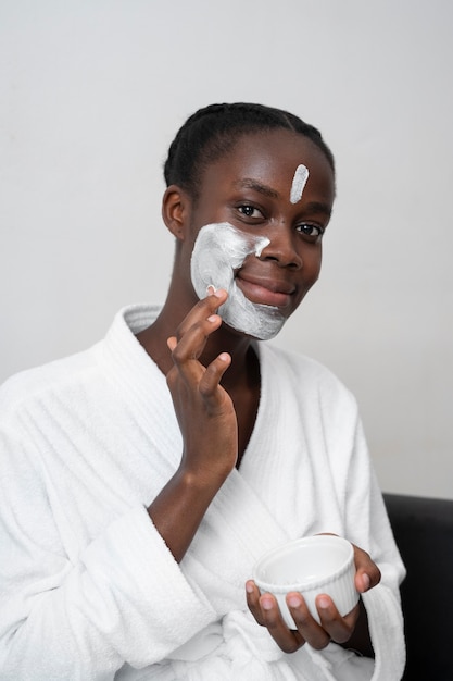 Bella mujer haciendo un tratamiento facial en casa