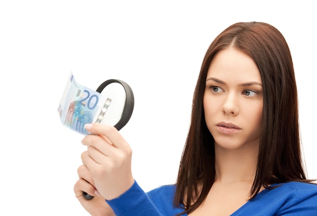 Bella mujer con lupa y dinero en efectivo en euros