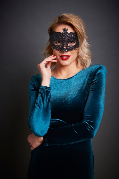 Bella mujer con máscara de mascarada en tiro de estudio