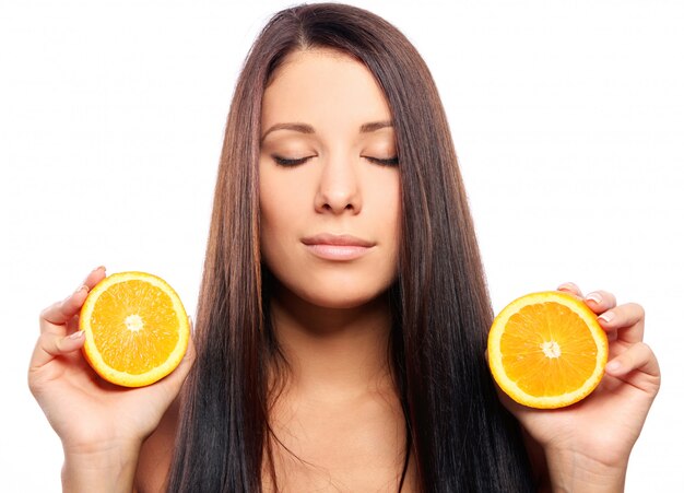 Bella mujer con naranja en manos