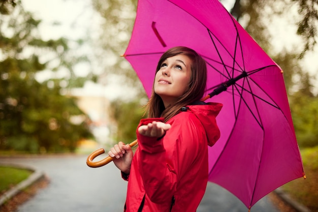 Bella mujer con paraguas buscando lluvia