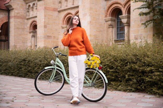 Bella mujer posando junto a la bicicleta fuera