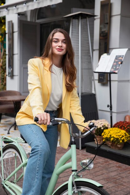 Bella mujer posando con su bicicleta en la calle