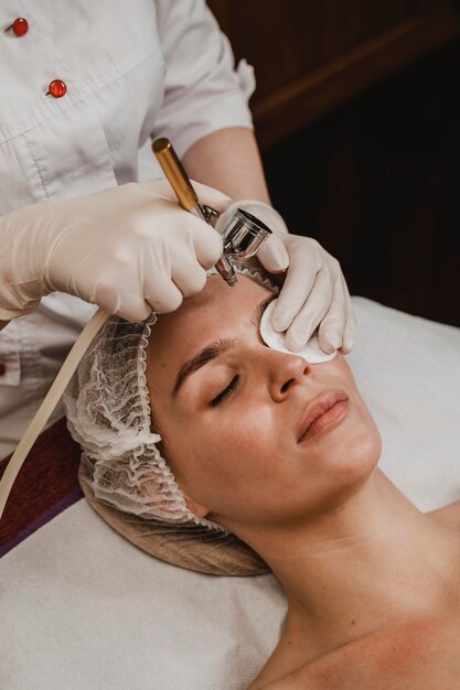 Bella mujer recibiendo un tratamiento cosmético en el centro de bienestar