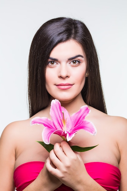 Bella mujer sonriente con un lirio aislado sobre fondo blanco.