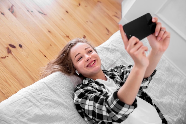 Foto gratuita bella mujer sonriente con smartphone