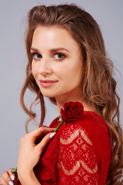Bella mujer sosteniendo una rosa roja