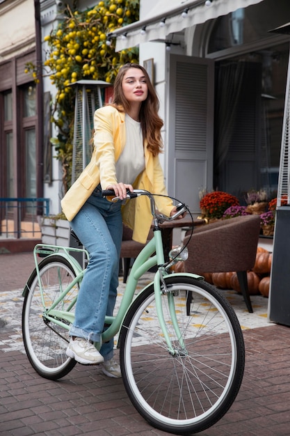 Bella mujer con su bicicleta en la calle
