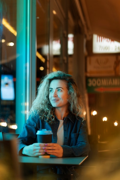 Foto gratuita bella mujer tomando café durante una noche de fiesta