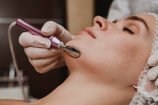 Bella mujer con un tratamiento cosmético en el spa