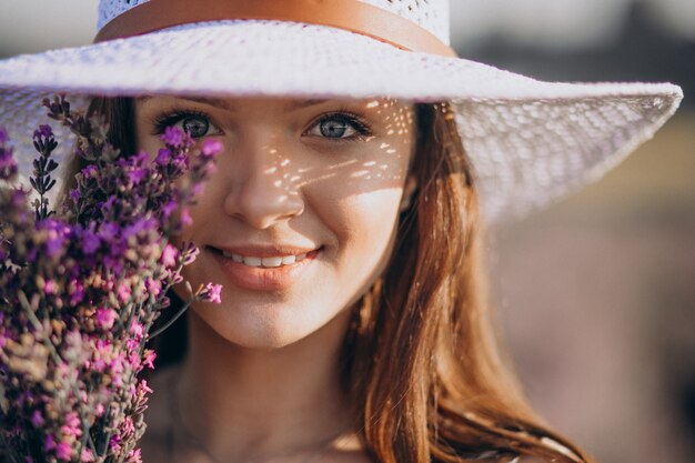 Bella mujer en vestido blanco en un campo de lavanda