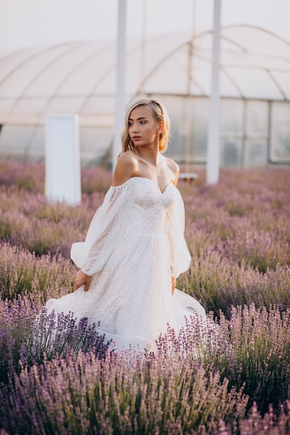 Bella mujer en vestido de novia en campo lavanda
