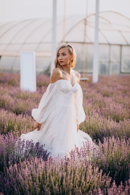 Bella mujer en vestido de novia en campo lavanda