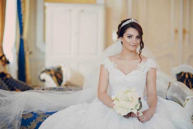 bella novia en un magnífico vestido blanco y una corona en la cabeza