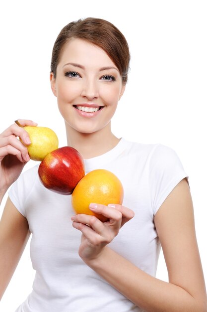Belleza de joven mujer riendo sosteniendo algunas frutas