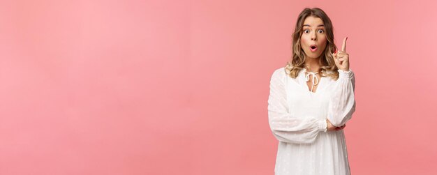 Belleza moda y mujeres concepto retrato de niña rubia femenina asombrada y emocionada en vestido blanco o