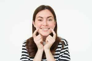 Foto gratuita belleza y mujeres concepto joven mujer sonriente mostrando sus bonitos hoyuelos en la cara y pareciendo feliz