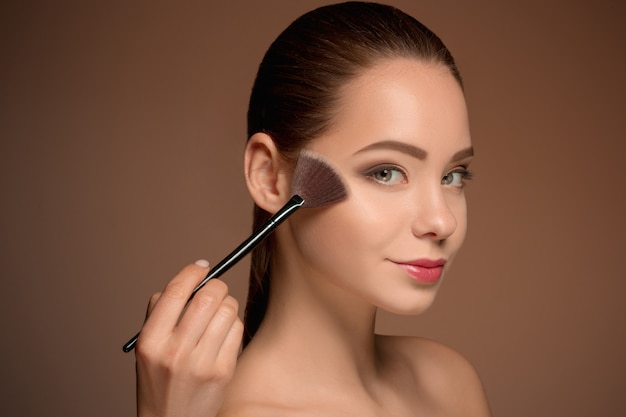 Bellezas con pincel de maquillaje. Piel perfecta. Aplicar maquillaje