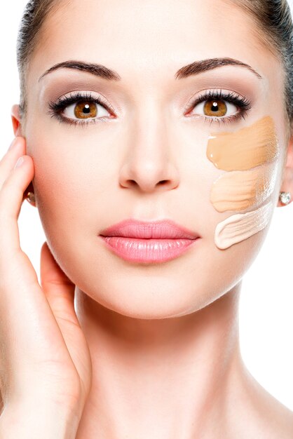 Bello rostro de mujer joven con base cosmética en la piel. Concepto de tratamiento de belleza