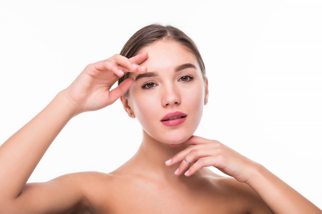 Bello rostro de mujer joven con la piel limpia y fresca aislada en la pared blanca